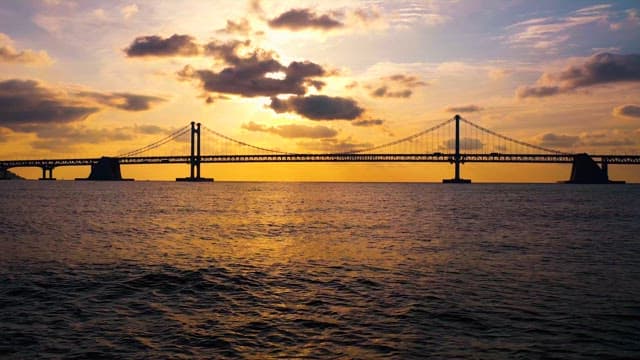 Sunset at Sea Featuring Silhouette of Bridge
