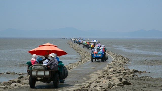 Fishermen passing through the tidal flats to catch fish