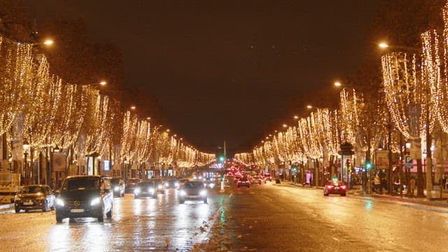 Nighttime view of a bustling city street adorned with festive lights