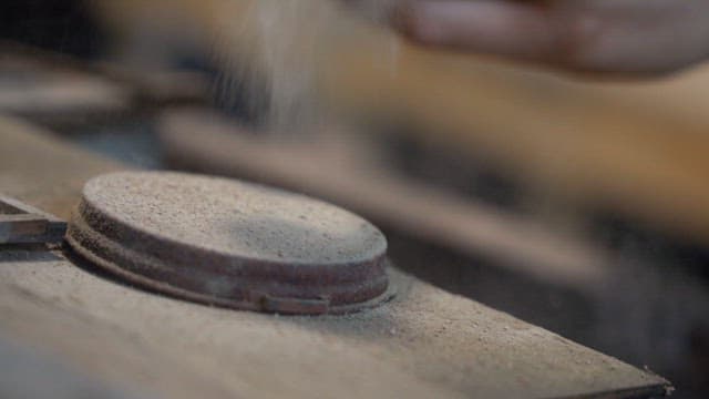 Dusty cover on industrial equipment with particles rising