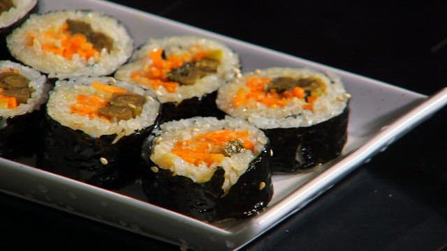 Plate of kimbap with mustard leaves and carrots