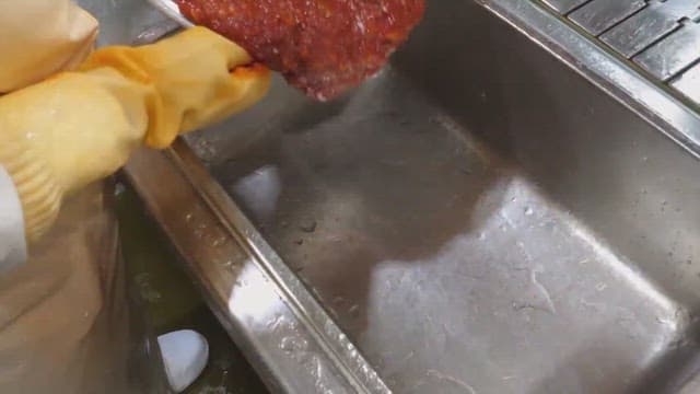 Mixing red chili paste in a stainless steel sink