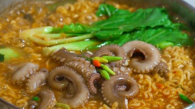 Korean seafood ramen with octopus boiling in a pot