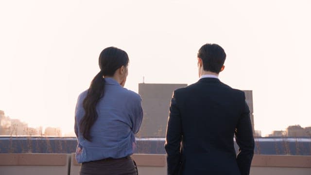 Two people talking on a rooftop
