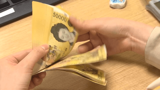 Person handling 50,000 won banknote, Korean currency at a bank