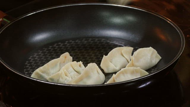 Dumplings fried in an oiled frying pan