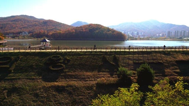 Beautiful Baegunhosu Lake with autumn trees and a view of the walking trail of people