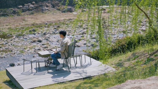 Man Relaxing Comfortably under a Swaying Willow
