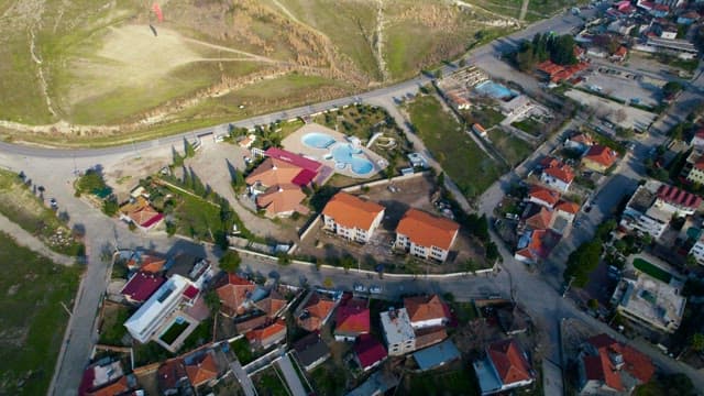 Village next to a Hill with Paraglider