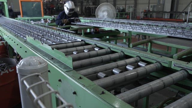 Worker welding metal structures in a factory