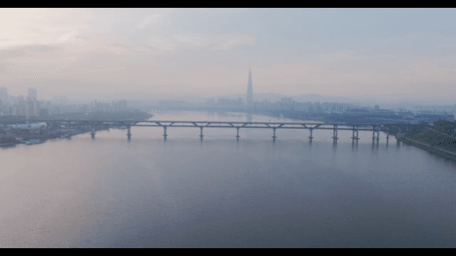 Bridge over a calm river with city skyline