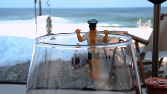 Drinking wine with a wine glass decorated with figures near the beach