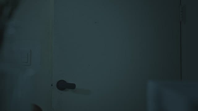 Girl opening the door and entering a dark room