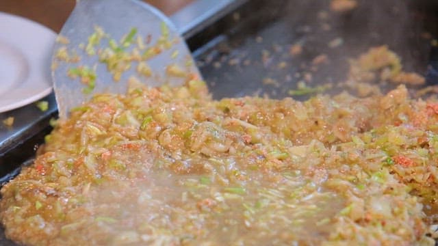 Stir-frying vegetables and rice on a griddle