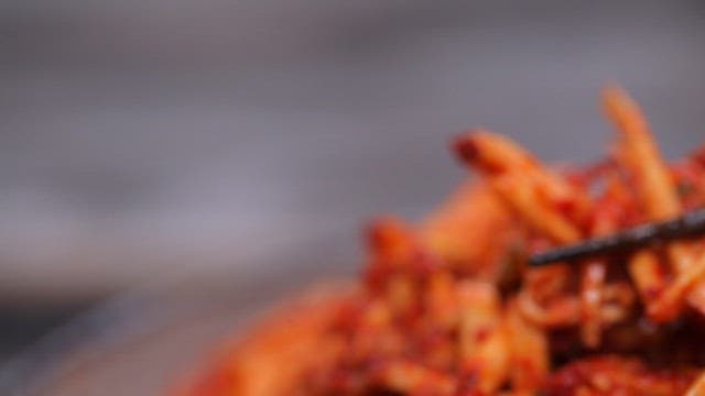 Chopsticks holding spicy Korean sweet potato salad