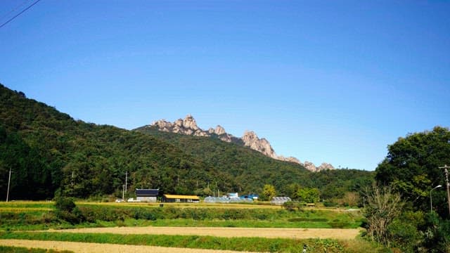 Farmhouses with mountain range under clear blue sky