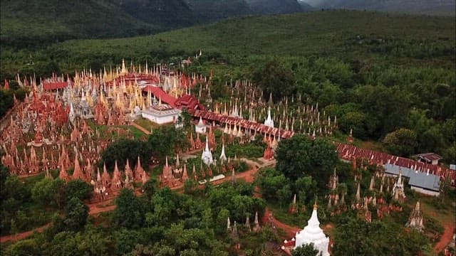 Inn Dein historic site filled with Buddhist statues amidst dense forests