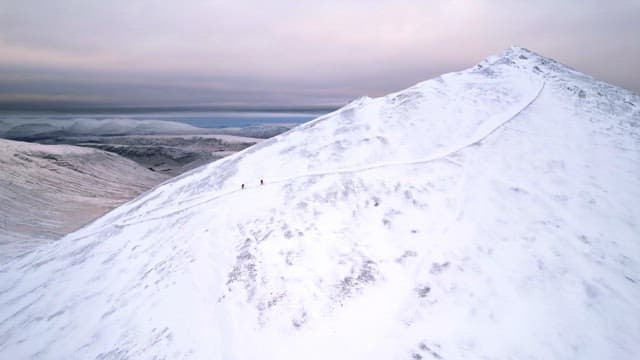 Snow-covered mountain with hikers