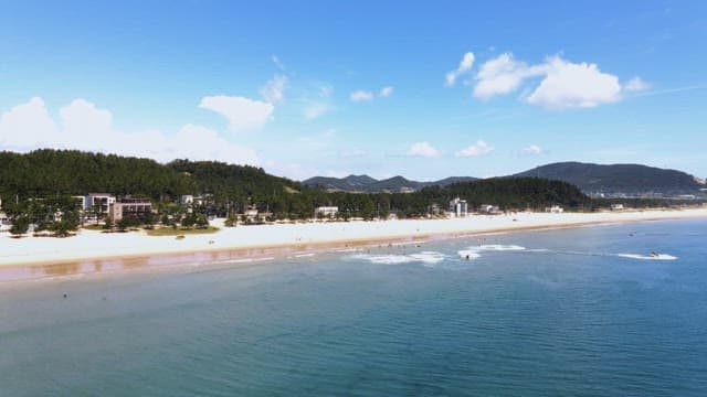Serene beach with waves and distant mountains