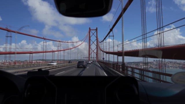 View from a Car Driving on a Bridge over a River on a Sunny Day