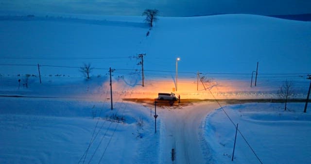 Car on a Snowy Road at Twilight