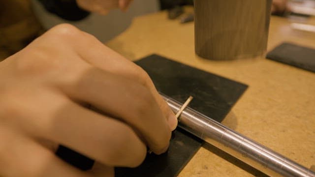 Man Hammering to Bend Metal in a Workshop