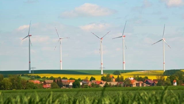Wind Generator Standing in Field and Rural Houses