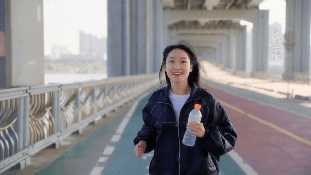 Woman jogging on a jamsu bridge with a smile