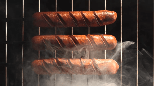 Three sausages slightly charred with smoke