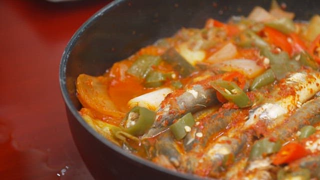 Fresh and spicy fish stew with chili peppers boiling