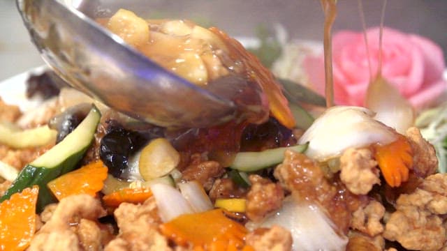 Sweet and sour sauce poured over fried meat