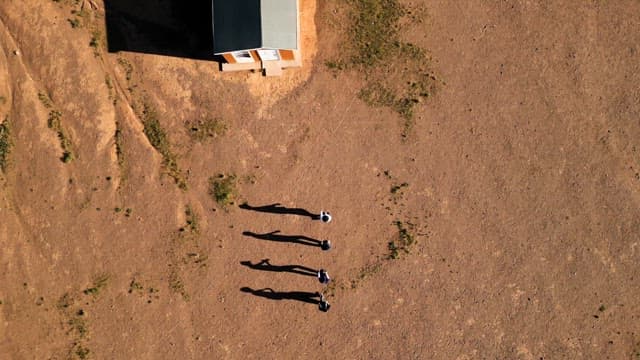 People walking near a small house
