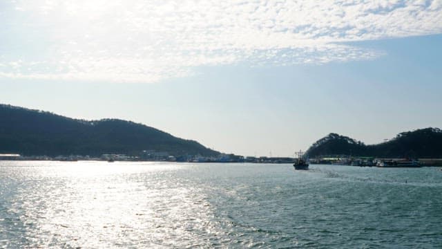 Ship passing by on sparkling waves in a clear sky