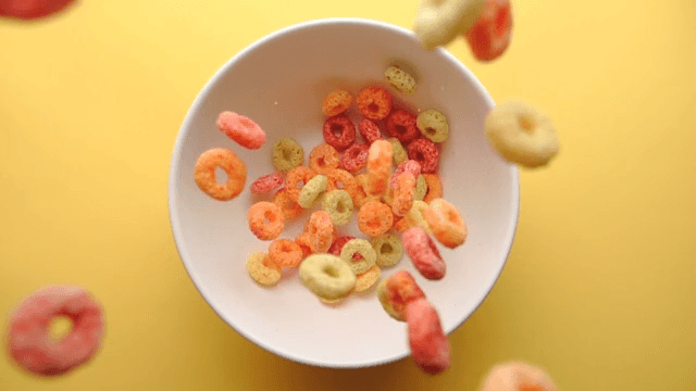 Slow-motion shot of cereal falling into a white bowl