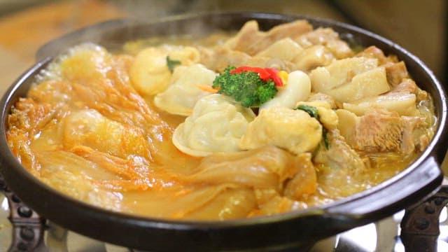 Braised aged kimchi and pork with dumplings and vegetables