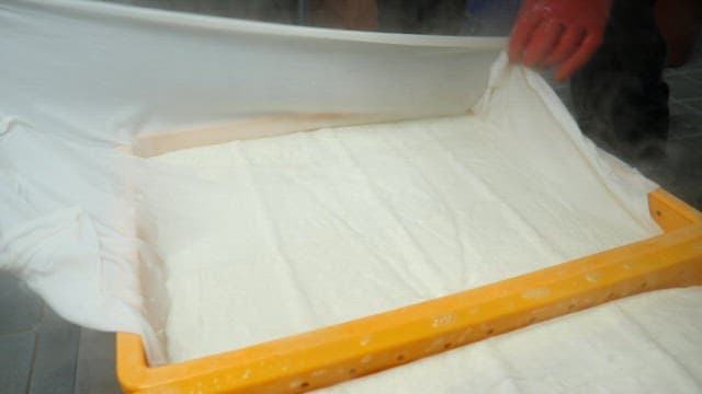 Handling steaming tofu in the kitchen