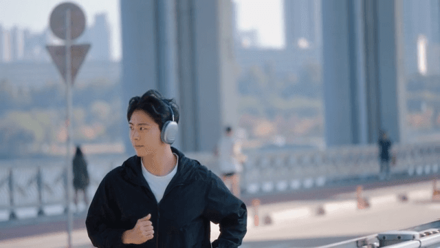 Person jogging on a bridge with headphones