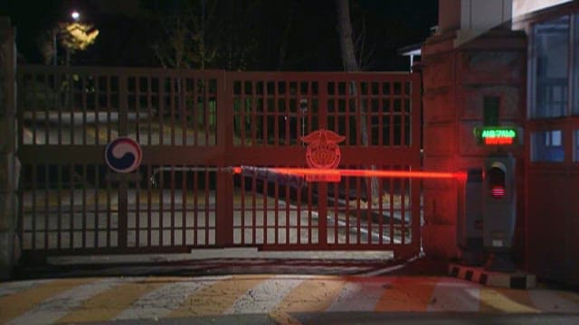 Entrance to a Correctional Facility with Closed Crossing Gate at Night
