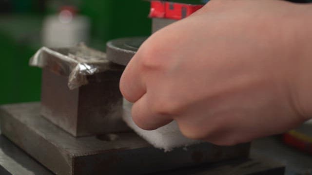 Worker operating a metal press machine