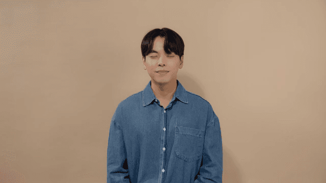 Man meditating with his eyes closed and a satisfied smile on his face