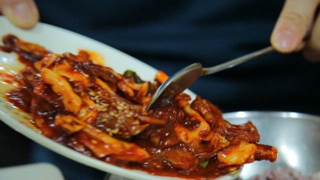 Spoonful of bibimbap with stir-fried squid and pork