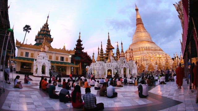 People gathered in the square in front of Shwedagon Pagoda at sunset