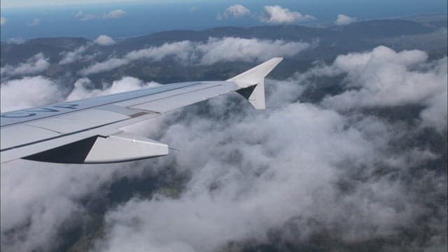 Wing of an airplane flying above the clouds