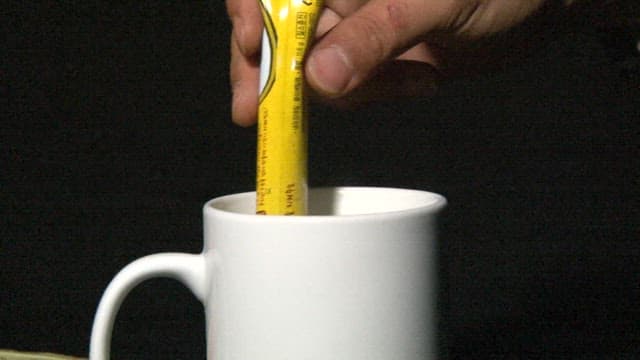 Mixing coffee in the mug with a bag