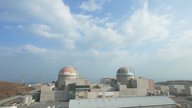 Nuclear power plant with cooling towers under blue sky