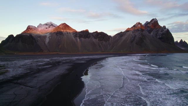 Serene beach with waves and mountains