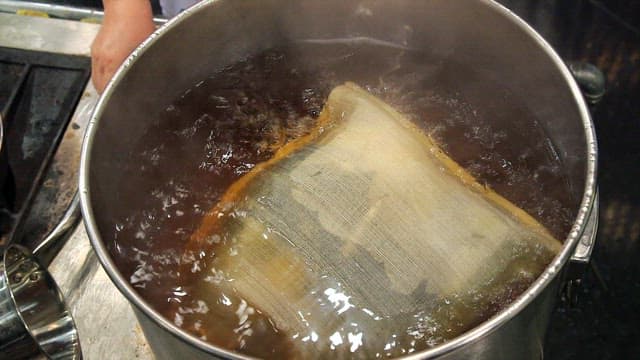 Broth boiling in a pot with a ladle