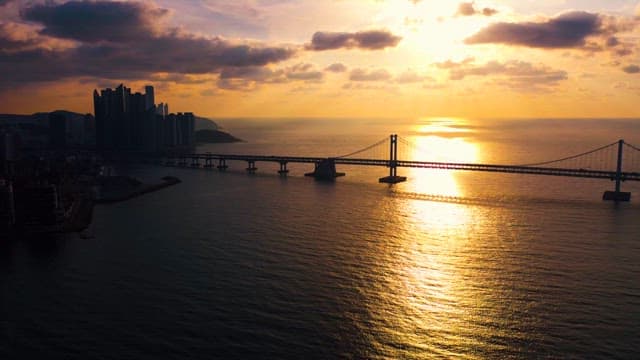 Sunrise Over City Skyline and Ocean Bridge