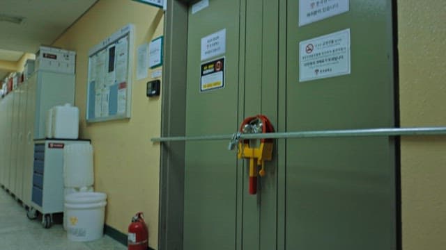 Cluttered Chairs in a Corridor of a Building and a Tightly Locked Door
