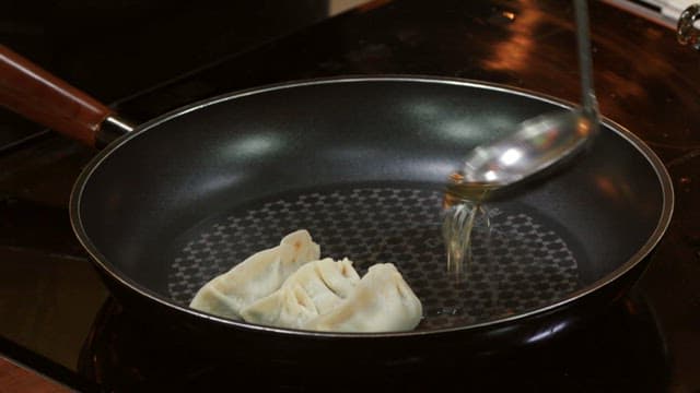 Dumplings fried in an oiled frying pan